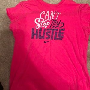 Pink nike shirt that says “can’t stop my hustle”